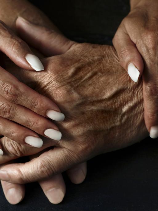 Zwei Menschen, die sich an den Händen halten Zwei Menschen, die sich an den Händen halten