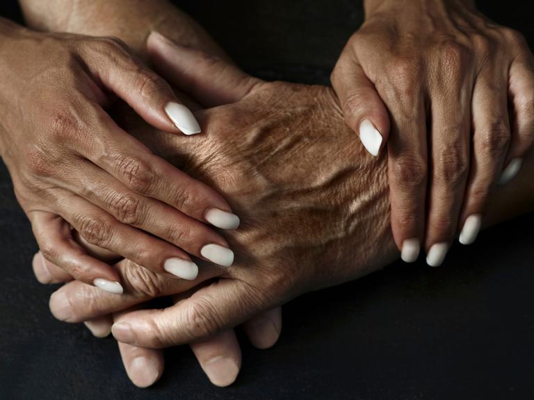 Zwei Menschen, die sich an den Händen halten Zwei Menschen, die sich an den Händen halten