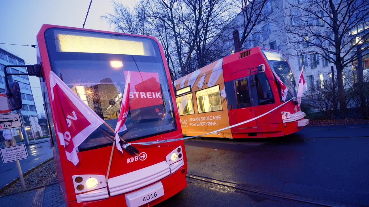 Verdi-Fahnen sind an den Frontscheiben zweier nebeneinander stehenden Straßenbahnen angebracht (Köln, 02.02.2026)