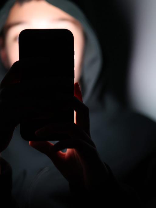 Ein Kind schaut auf ein Smartphone