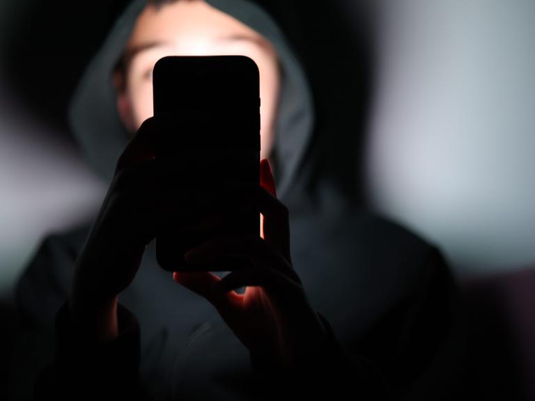 Ein Kind schaut auf ein Smartphone