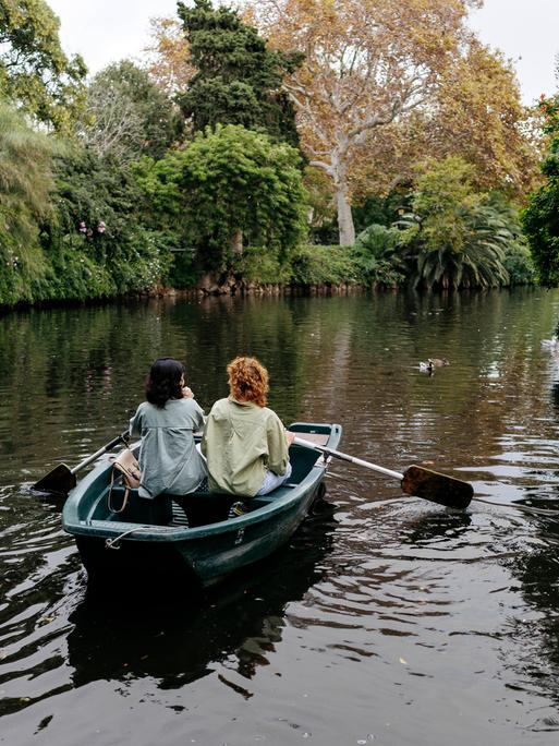 Lesbisches Pärchen in einem Ruderboot auf einem Weiher in Barcelona. Ringsum viel Grün. Lesbisches Pärchen in einem Ruderboot auf einem Weiher in Barcelona. Ringsum viel Grün.