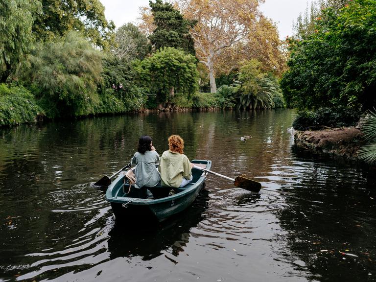 Lesbisches Pärchen in einem Ruderboot auf einem Weiher in Barcelona. Ringsum viel Grün. Lesbisches Pärchen in einem Ruderboot auf einem Weiher in Barcelona. Ringsum viel Grün.