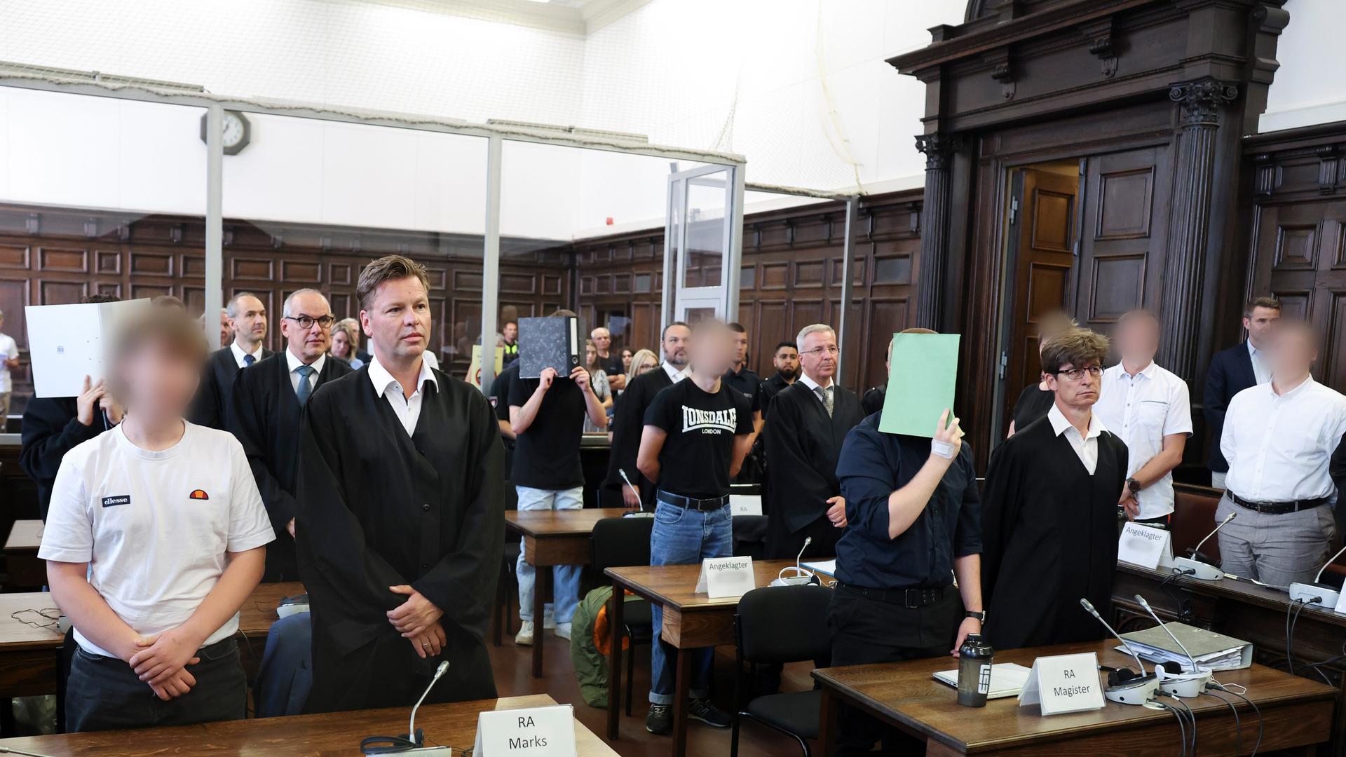 Sieben Angeklagte stehen mit ihren Verteidigern im Sitzungssaal im Hamburger Strafjustizgebäude zu Beginn des Prozesses gegen die rechtsextreme Terrorgruppe „Letzte Verteidigungswelle“.