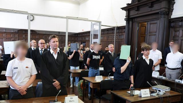 Sieben Angeklagte stehen mit ihren Verteidigern im Sitzungssaal im Hamburger Strafjustizgebäude zu Beginn des Prozesses gegen die rechtsextreme Terrorgruppe „Letzte Verteidigungswelle“.