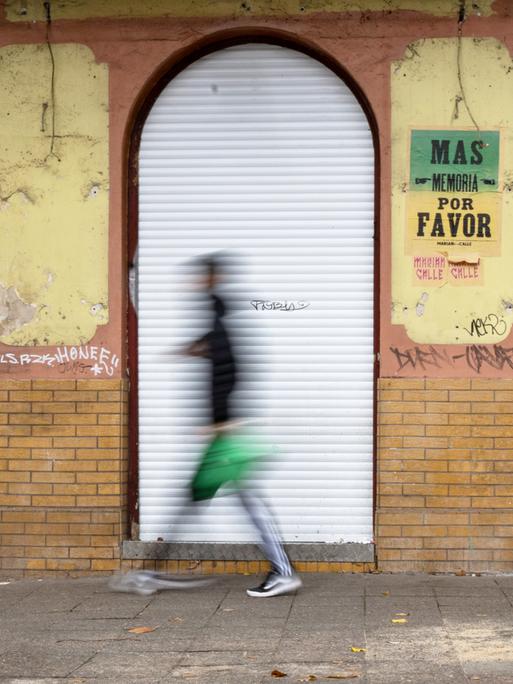 Verschommene Person geht an geschlossener Kneipe vorbei Verschommene Person geht an geschlossener Kneipe vorbei