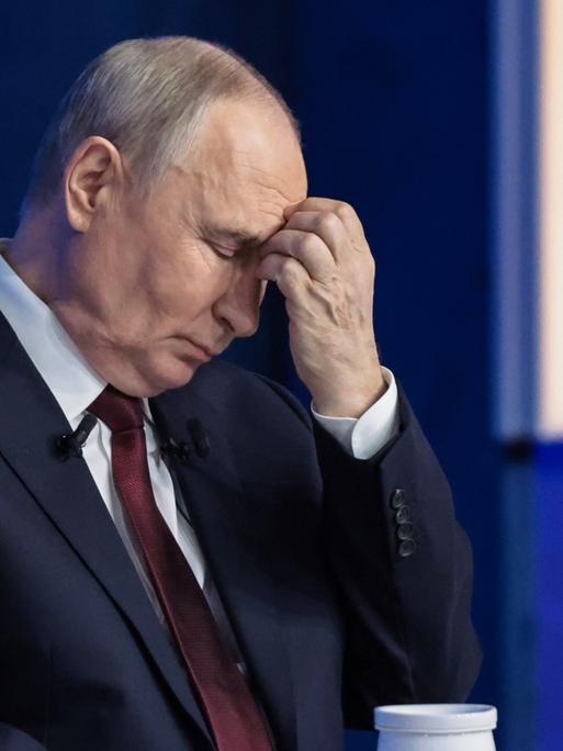 Der russische Präsident Wladimir Putin mit geschlossenen Augen und Hand an der Stirn während der mehrstündige Live-Fernsehshow Ergebnisse des Jahres".