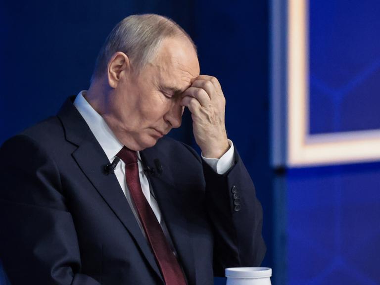 Der russische Präsident Wladimir Putin mit geschlossenen Augen und Hand an der Stirn während der mehrstündige Live-Fernsehshow Ergebnisse des Jahres".