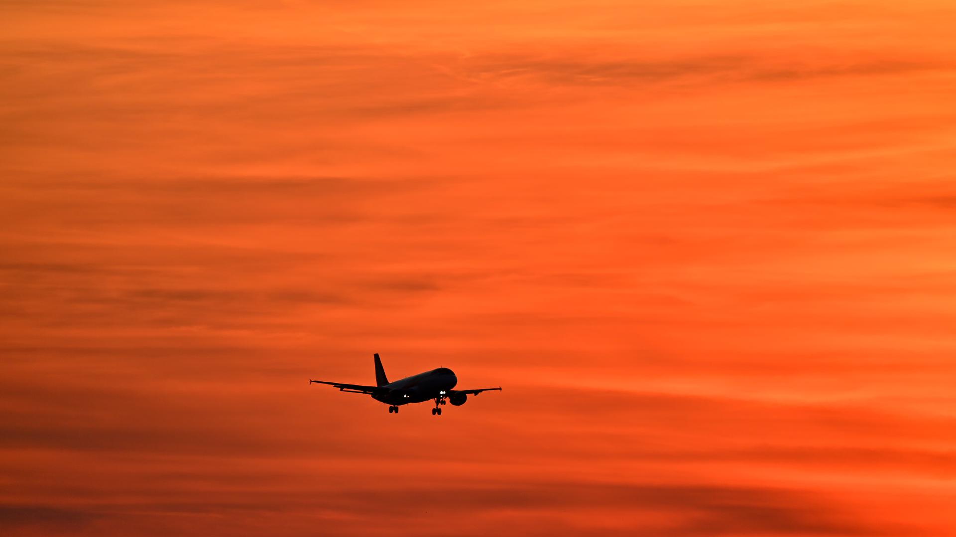 Flugzeuge am Airport Muenchen fliegt im Sonnenuntergang