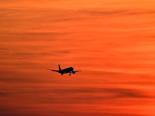Flugzeuge am Airport Muenchen fliegt im Sonnenuntergang