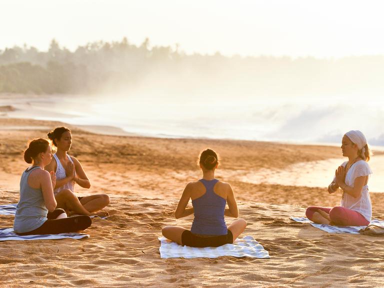 Eine Gruppe macht zusammen Yoga am Strand