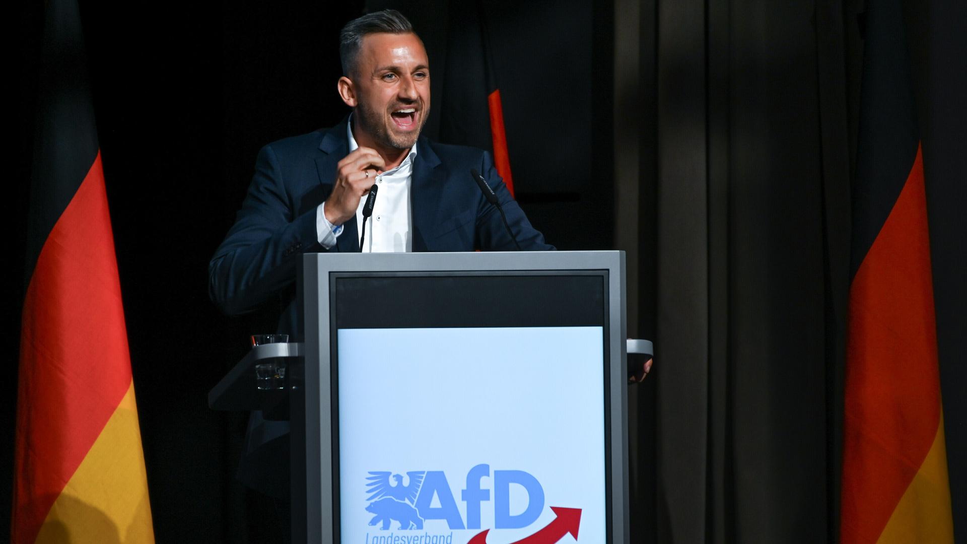 Ulrich Siegmund, Spitzenkandidat der AfD in Sachsen-Anhalt, umgeben von Deutschlandflaggen bei einer Rede