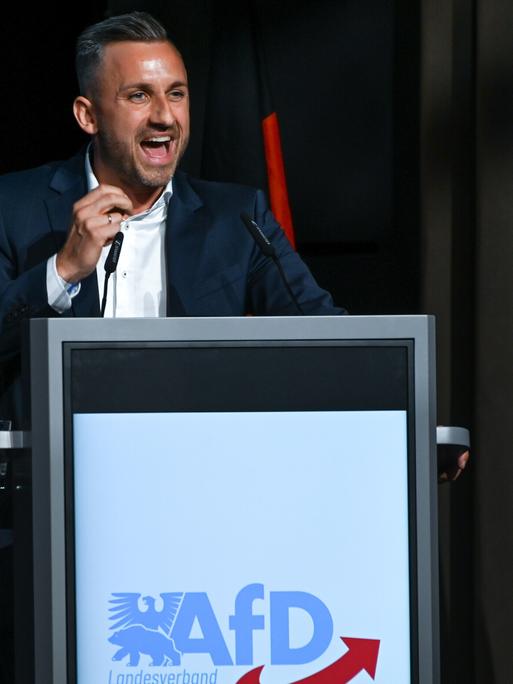 Ulrich Siegmund, Spitzenkandidat der AfD in Sachsen-Anhalt, umgeben von Deutschlandflaggen bei seiner Rede vor den Teilnehmern des Landesparteitages.