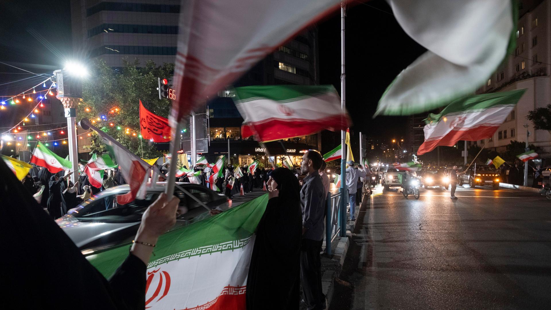In Teheran schwenken Regierungs-Anhänger iranische Flaggen In Teheran schwenken Regierungs-Anhänger iranische Flaggen