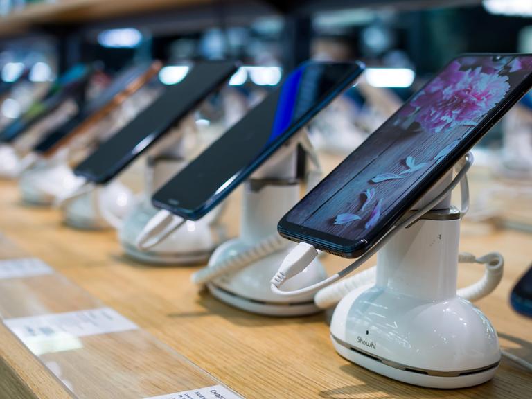 Mehrere Smartphones nebeneinander in einem Geschäft Mehrere Smartphones nebeneinander in einem Geschäft