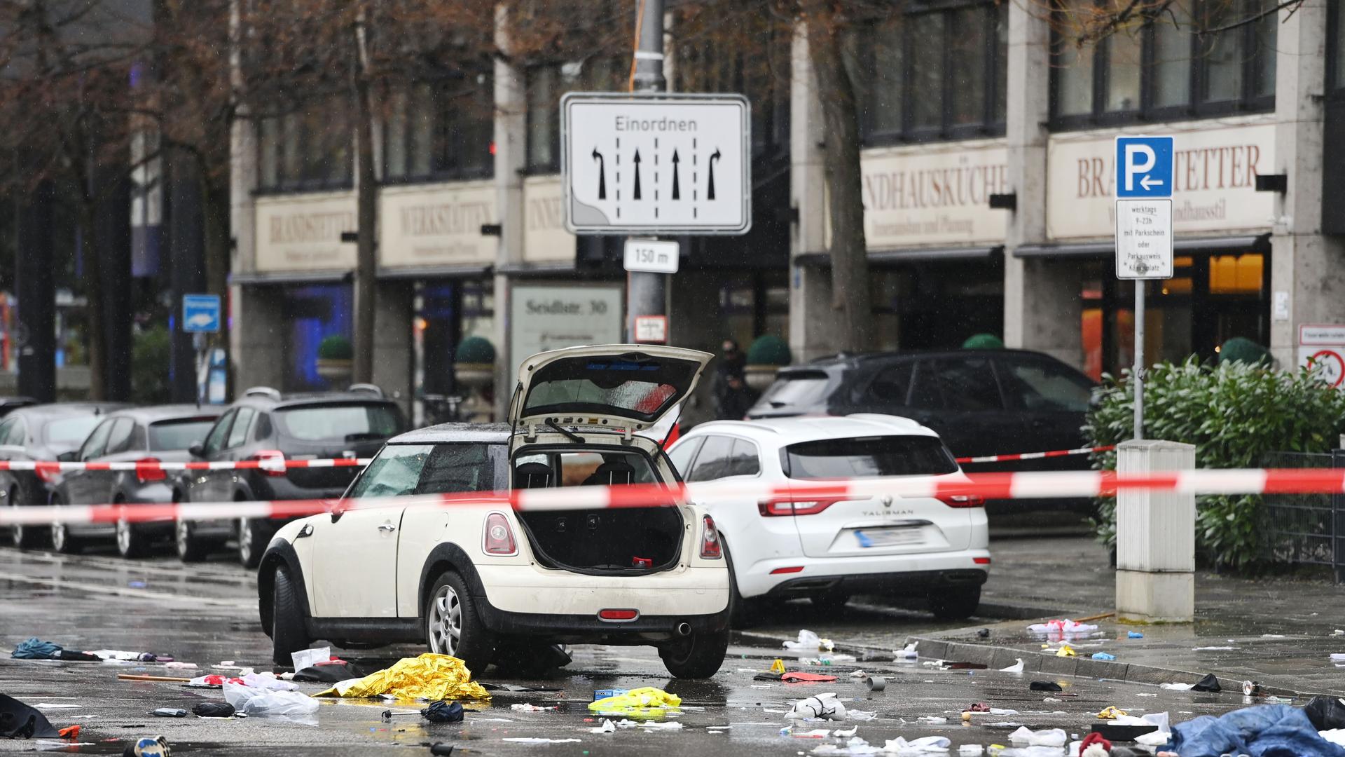 Ein Fahrzeug mit offenem Kofferraum, auf der Straße liegen viele Teile, davor ist ein Polizeiband gespannt.
