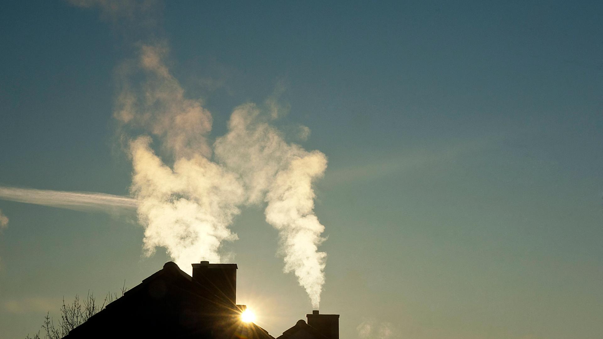 Rauch steigt aus den Schornsteinen zweier Wohnhäuser Rauch steigt aus den Schornsteinen zweier Wohnhäuser