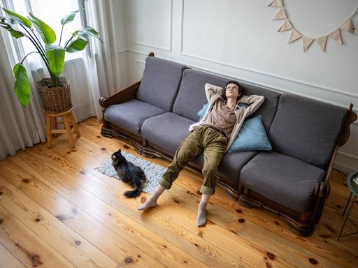 Eine Frau liegt gelangweilt auf dem Sofa