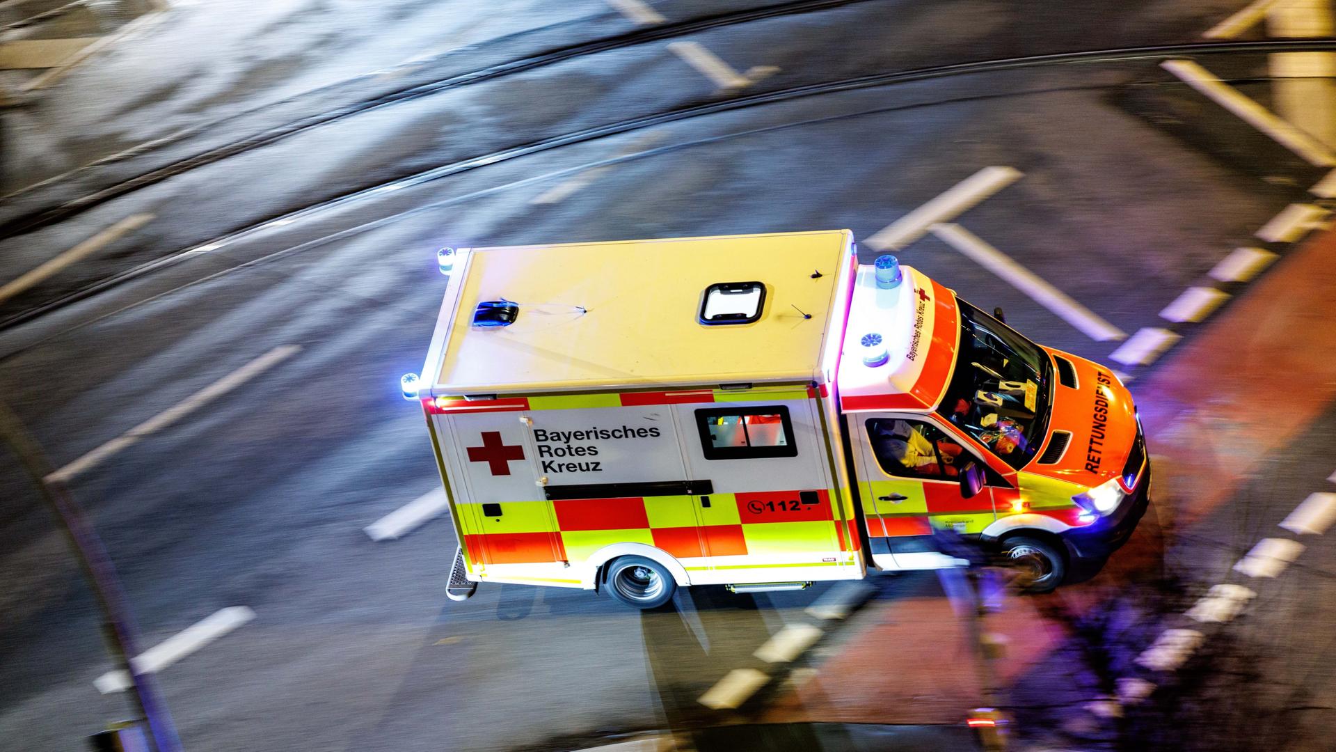 Ein Krankenwagen vom Bayerischen Roten Kreuz mit eingeschaltetem Blaulicht.