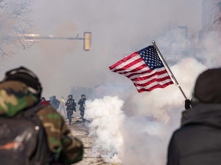 Bei Protesten in der US-Stadt Minneapolis geraten Protestierende und Sicherheitskräfte aneinander. Die Proteste wurden durch tödliche Schüsse, die von ICE-Beamten auf einen US-Bürger abgegeben wurden, ausgelöst. Bei Protesten in der US-Stadt Minneapolis geraten Protestierende und Sicherheitskräfte aneinander. Die Proteste wurden durch tödliche Schüsse, die von ICE-Beamten auf einen US-Bürger abgegeben wurden, ausgelöst.