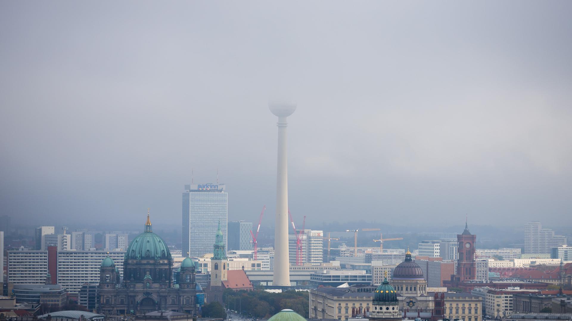 Der Berliner Fernsehturm verschwindet in tief hängenden Wolken. Der Berliner Fernsehturm verschwindet in tief hängenden Wolken.