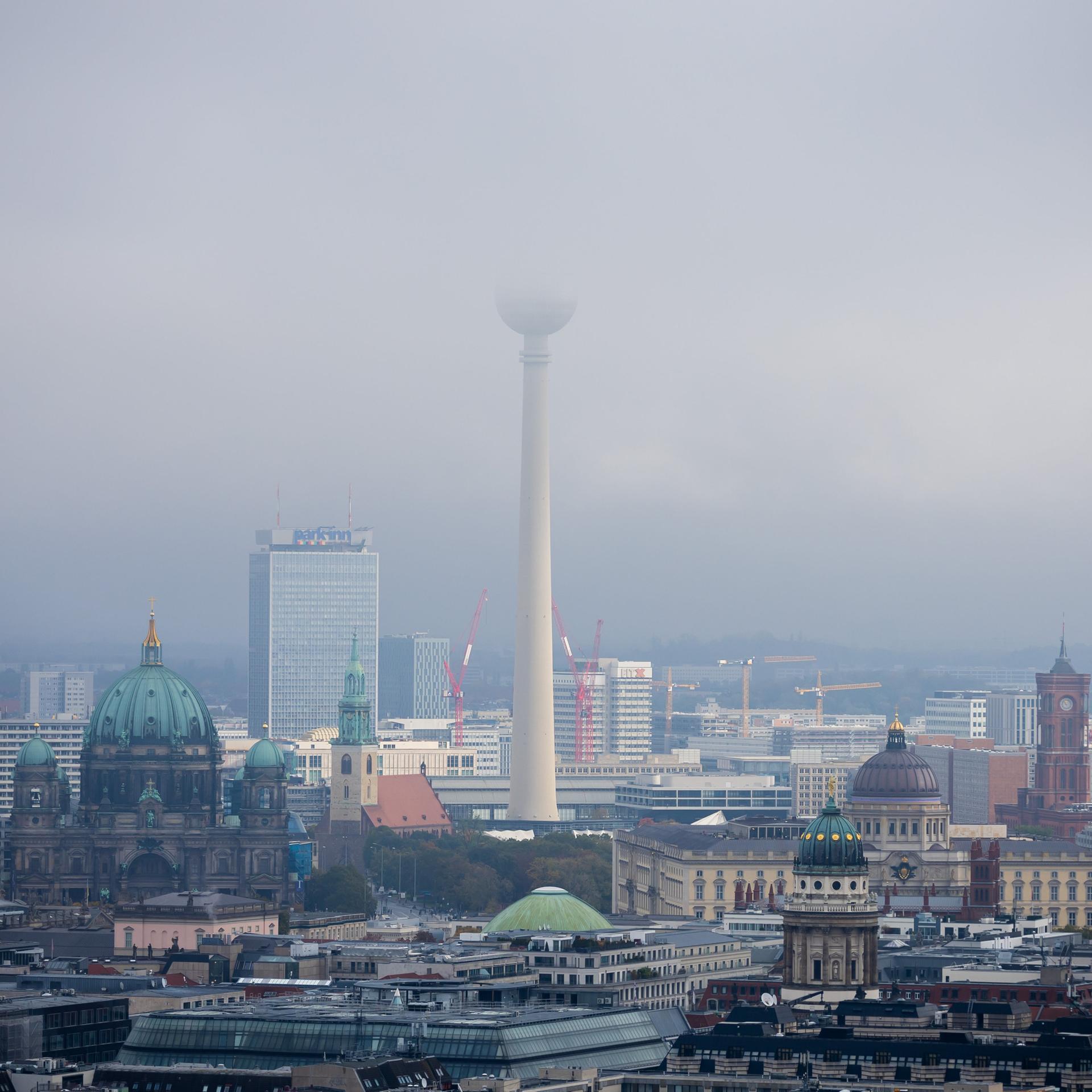 Der Berliner Fernsehturm verschwindet in tief hängenden Wolken.