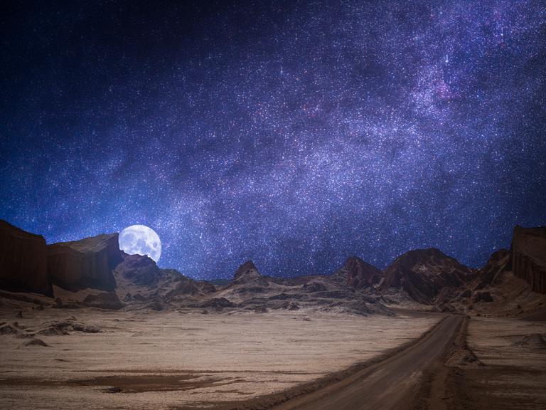 Das Valle de la Luna (Mondtal) in der Nähe von San Pedro de Atacama, Chile. Strahlender Sternenhimmel und Mond bei Nacht.