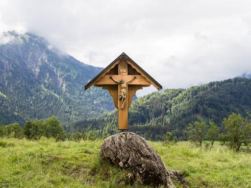 Ein Wegekreuz vor Bergkulisse