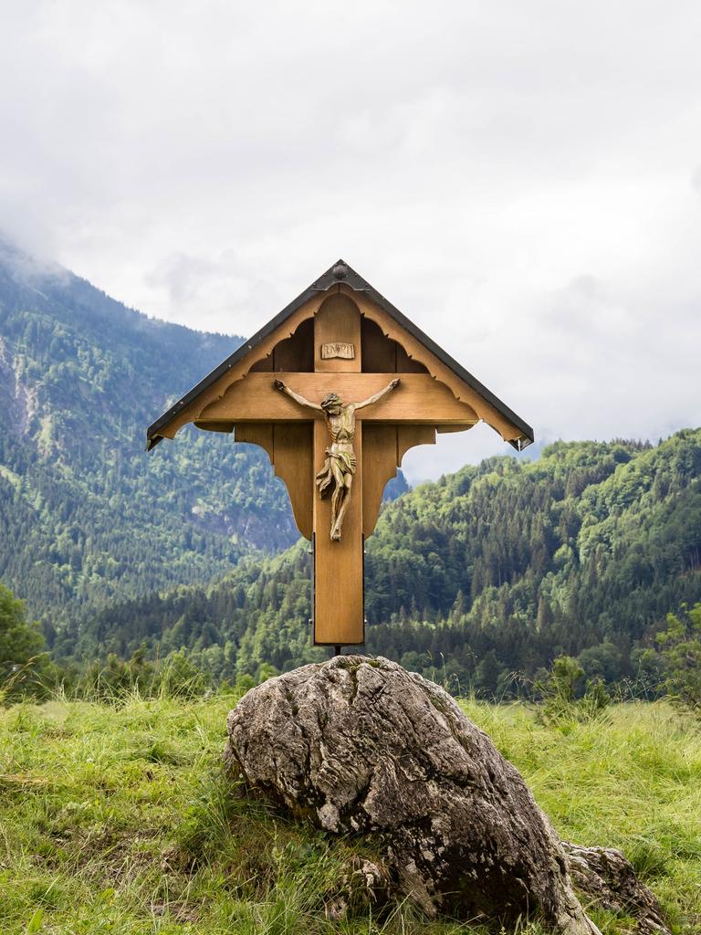 Ein Wegekreuz vor Bergkulisse