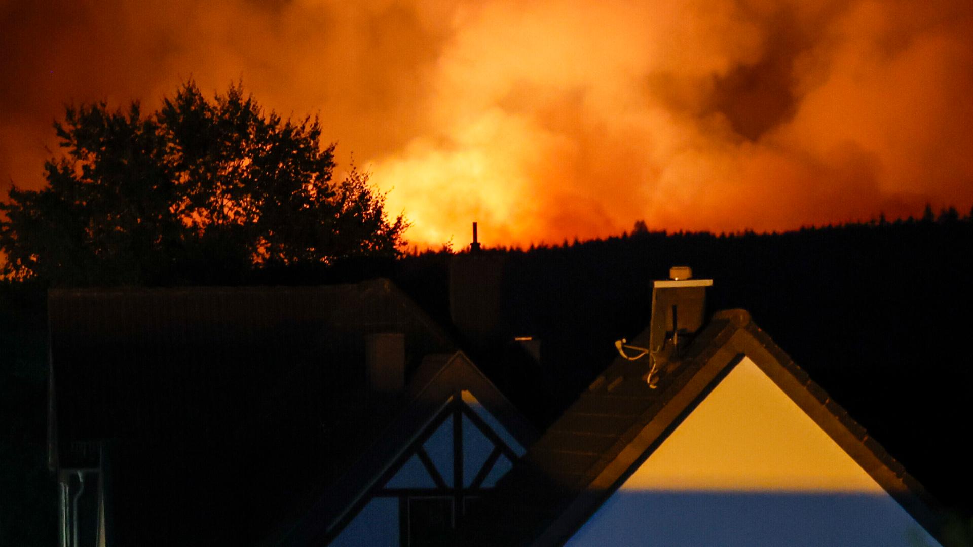 Ein Haus im Ortsteil Monschau-Kalterherberg, im Hintergrund steht das Hohe Venn in Flammen Ein Haus im Ortsteil Monschau-Kalterherberg, im Hintergrund steht das Hohe Venn in Flammen