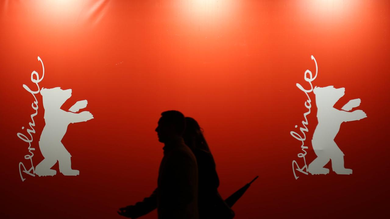 Fußgänger gehen im Vorfeld der 76. Internationalen Filmfestspiele Berlin (Berlinale) an einem großen Berlinale-Banner - vor dem Berlinale Palast - vorbei.