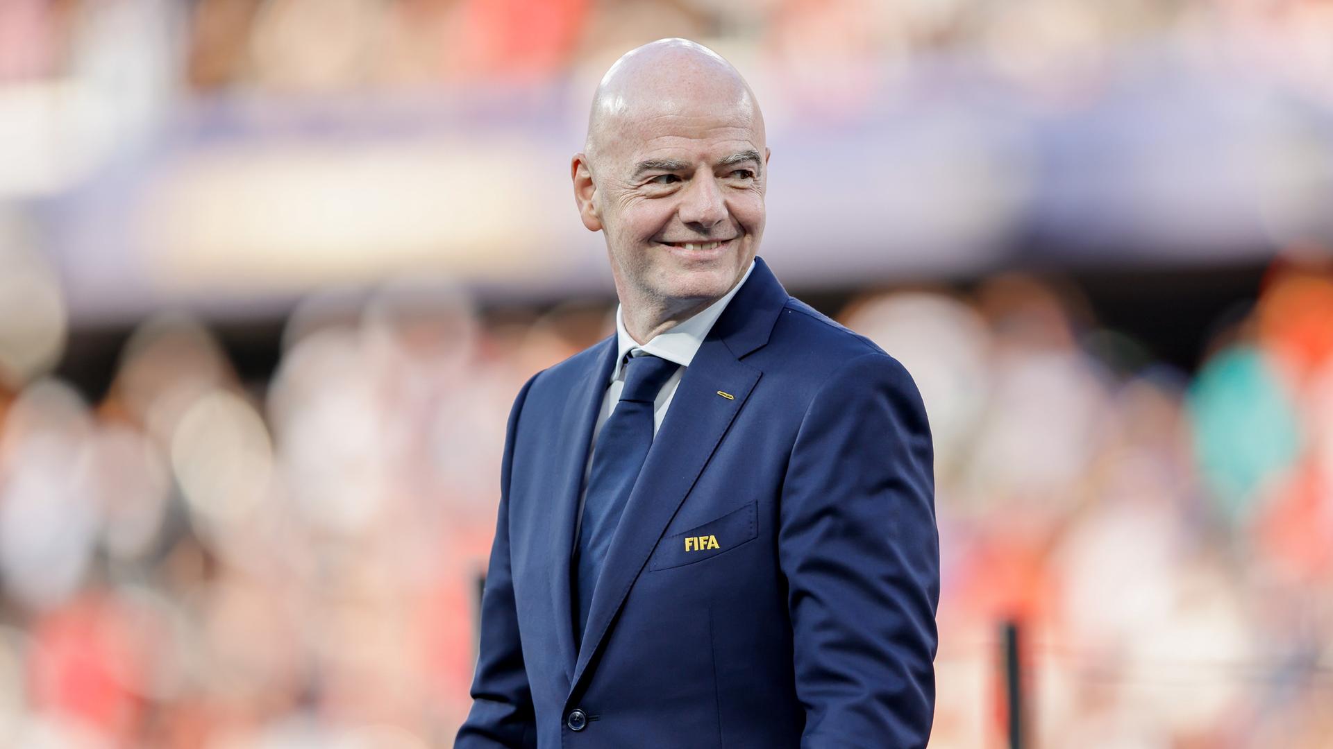 FIFA-Präsident Gianni Infantino läuft über das Fußballfeld beim WM-Spiel Spanien gegen Argentinien und lächelt. FIFA-Präsident Gianni Infantino läuft über das Fußballfeld beim WM-Spiel Spanien gegen Argentinien und lächelt.