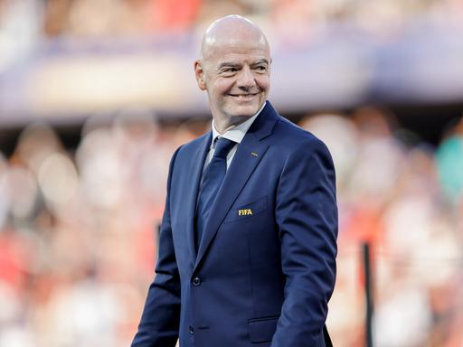 FIFA-Präsident Gianni Infantino läuft über das Fußballfeld beim WM-Spiel Spanien gegen Argentinien und lächelt. FIFA-Präsident Gianni Infantino läuft über das Fußballfeld beim WM-Spiel Spanien gegen Argentinien und lächelt.