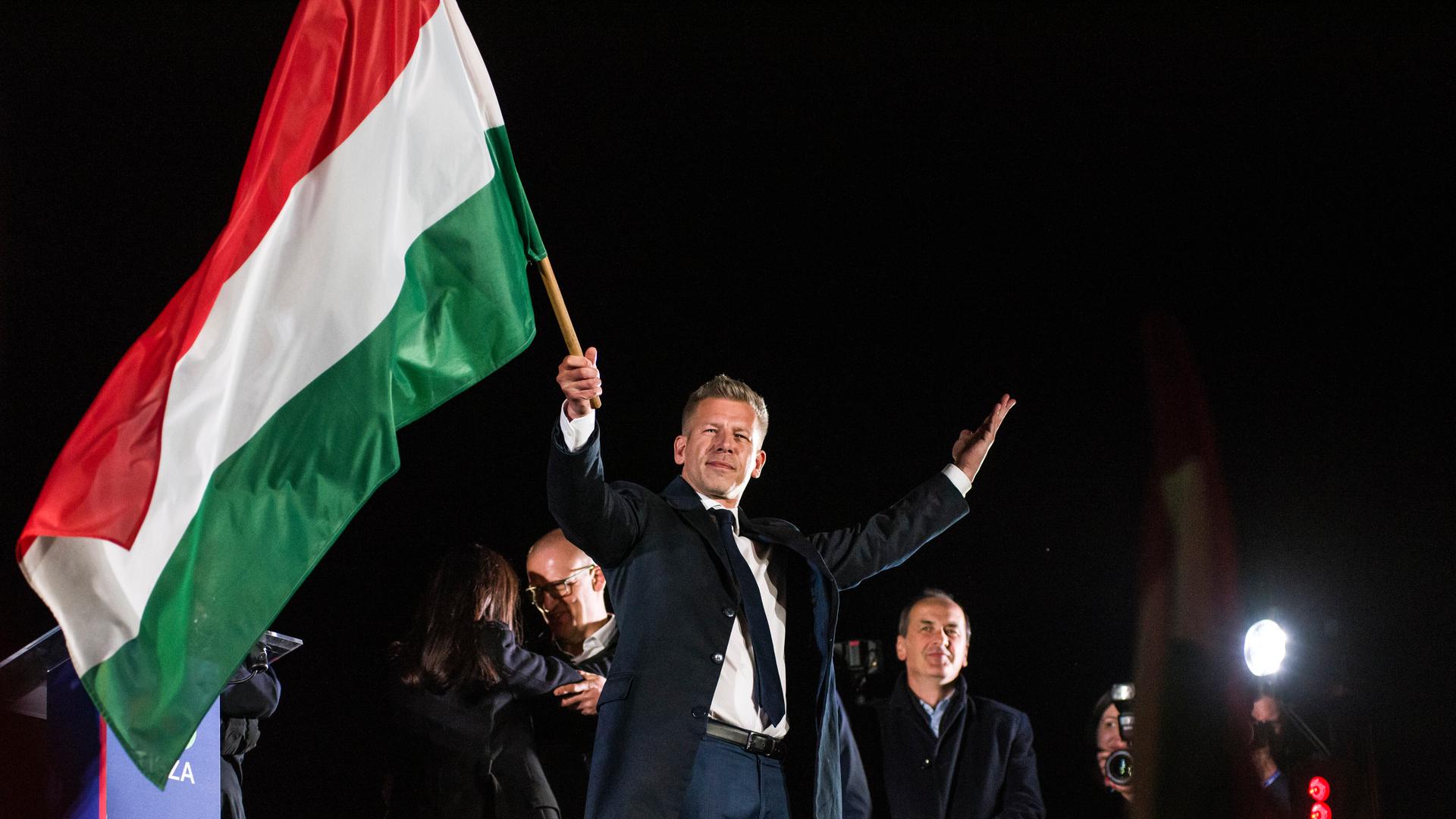 13. April 2026, Budapest, Ungarn: Peter Magyar schwenkt nach seiner Rede bei der Wahlparty der TISZA-Partei in Budapest die ungarische Flagge.