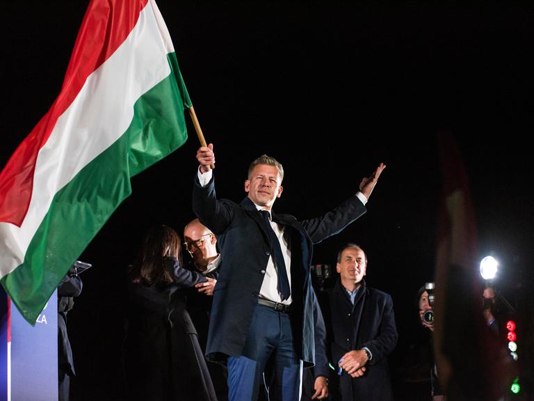 13. April 2026, Budapest, Ungarn: Peter Magyar schwenkt nach seiner Rede bei der Wahlparty der TISZA-Partei in Budapest die ungarische Flagge.