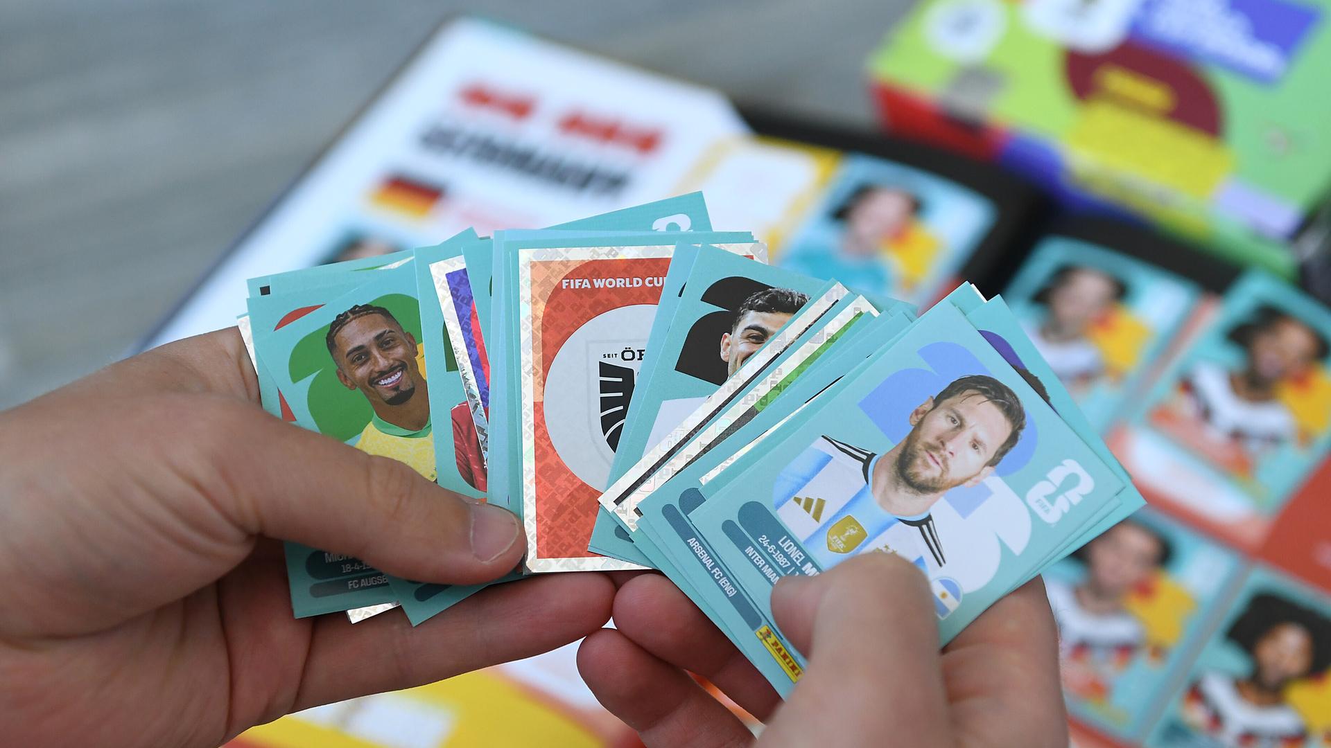 Eine Person hält Panini-Sticker in den Händen Eine Person hält Panini-Sticker in den Händen