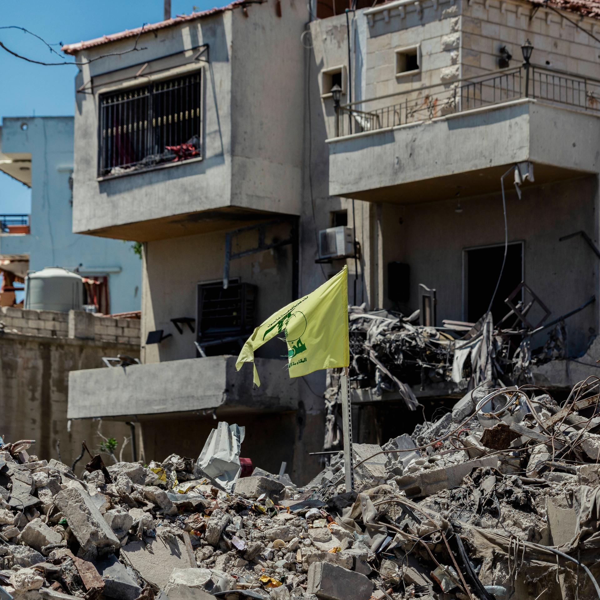 Zerstörung im Südlibanon-Krieg: Eine zerrissene Hisbollah-Flagge steht inmitten der Ruinen zerstörter Wohngebäude in Maifadoun im Südlibanon.