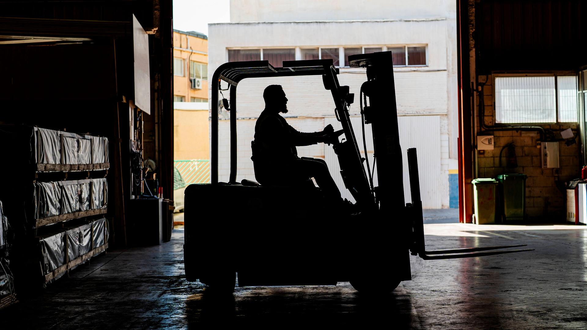 Ein Gabelstaplerfahrer im Gegenlicht