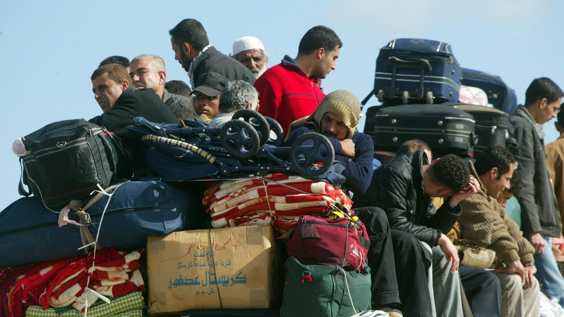 Palästinenser sitzen auf einem überfüllten Bus an der Grenze zu Ägypten in Rafah im Gazastreifen vor ihrer Ausreise