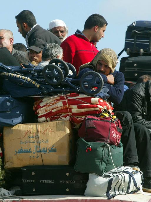 Palästinenser sitzen auf einem überfüllten Bus an der Grenze zu Ägypten in Rafah im Gazastreifen vor ihrer Ausreise