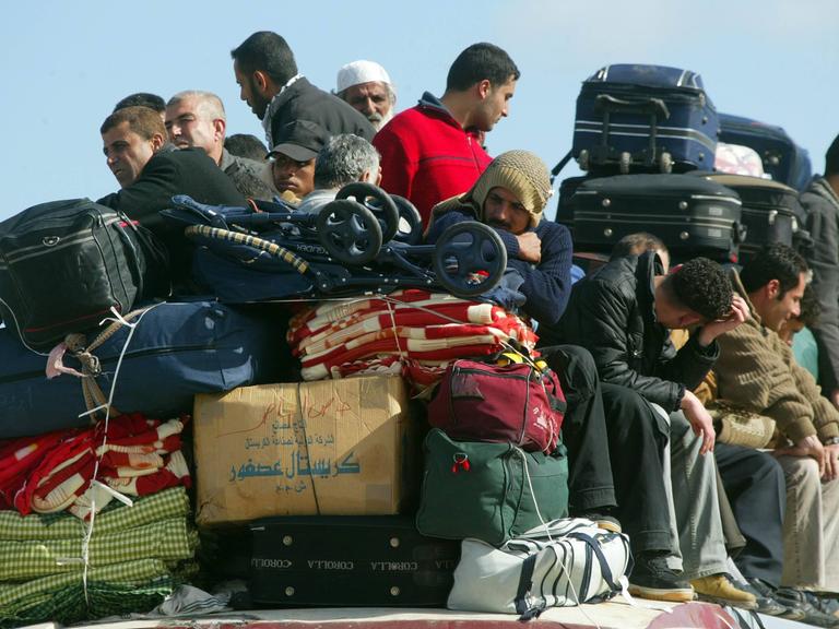 Palästinenser sitzen auf einem überfüllten Bus an der Grenze zu Ägypten in Rafah im Gazastreifen vor ihrer Ausreise