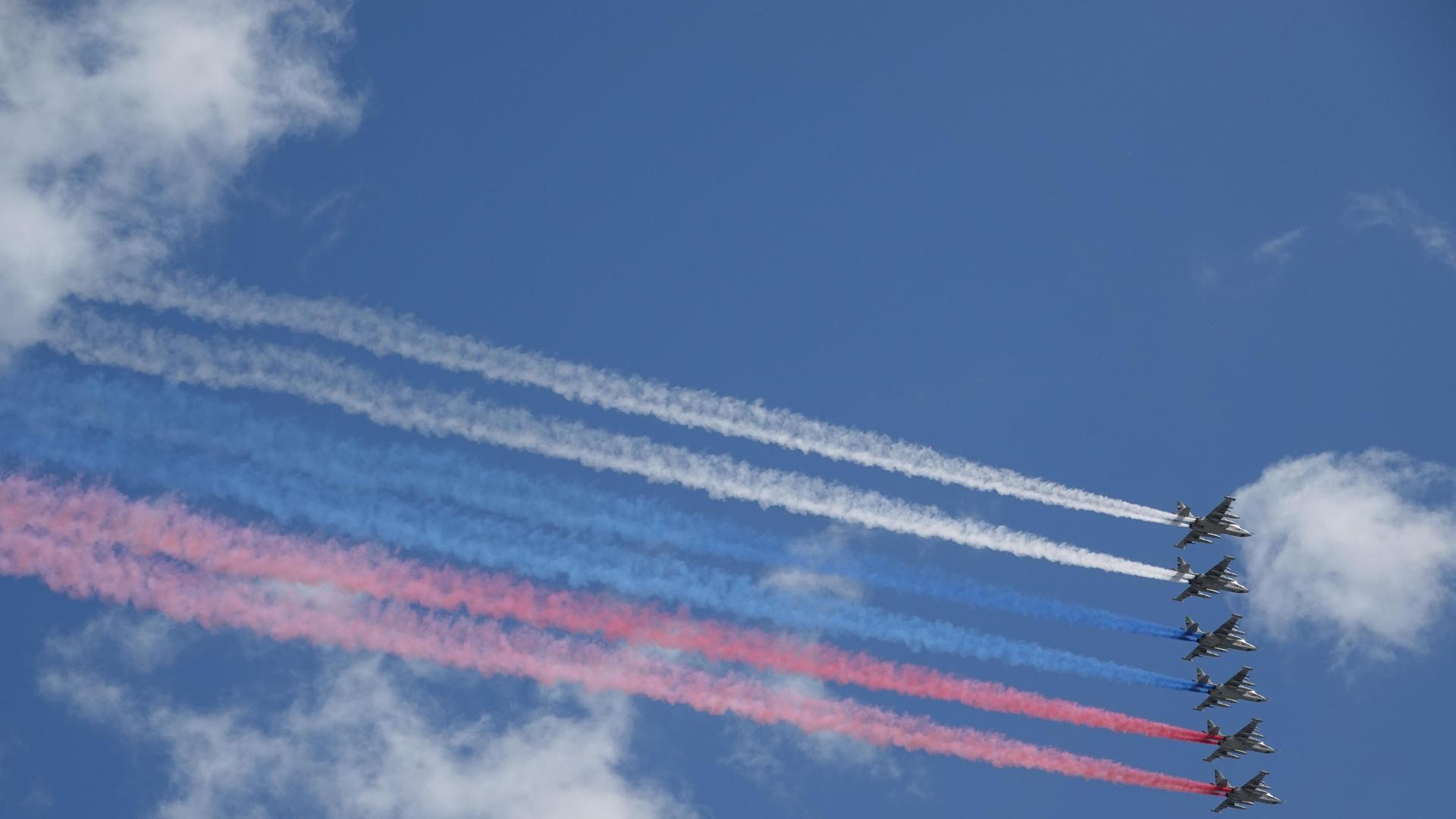 Die russischen Luftstreitkräfte fliegen bei der Militärparade über den Roten Platz und bilden mit farbigen Raum die russische Staatsflagge.