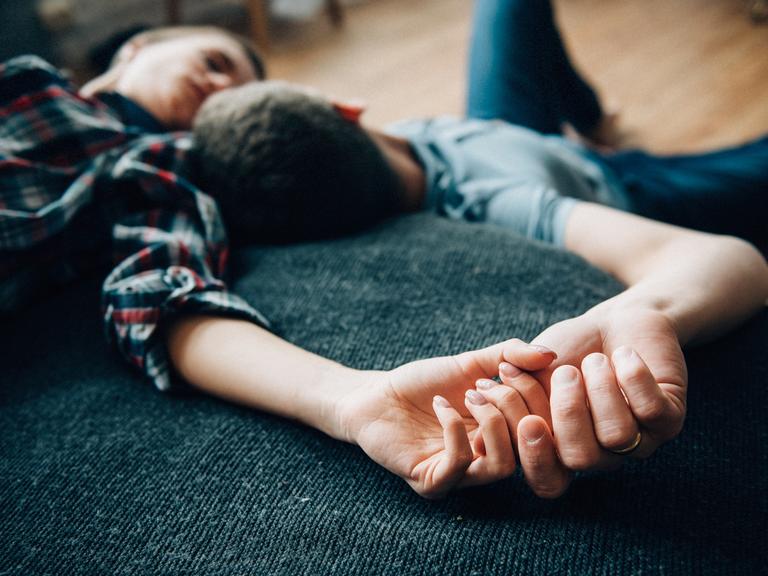 Eine Frau und ein Mann liegen auf dem Bett und schauen sich an