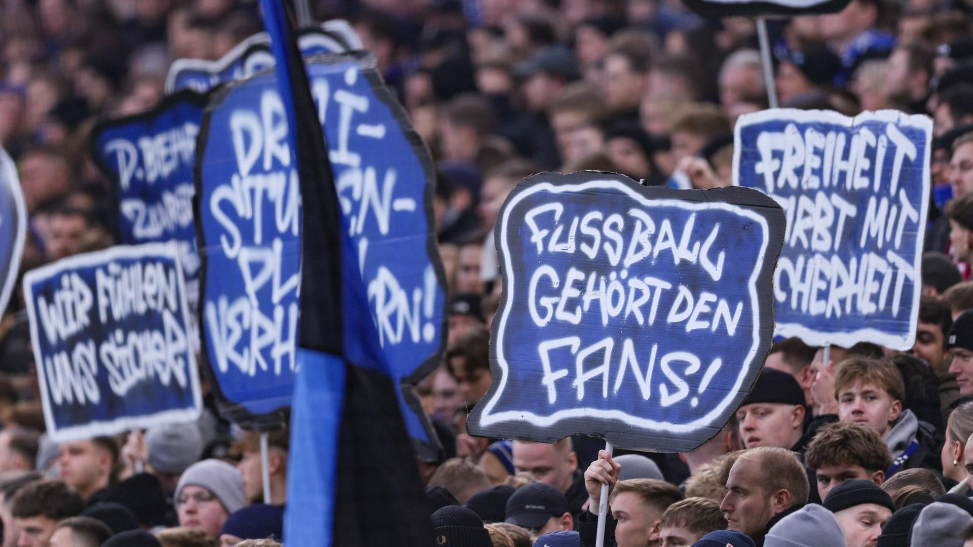 Am 30.11.2025 ein Spiel in der Fussball-Bundesliga; Hamburger SV gegen VfB Stuttgart. Fans halten Schilder in die Höhe, darauf steht: Fußball gehört den Fans.