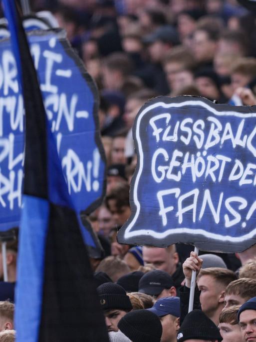 Am 30.11.2025 ein Spiel in der Fussball-Bundesliga; Hamburger SV gegen VfB Stuttgart. Fans halten Schilder in die Höhe, darauf steht: Fußball gehört den Fans.