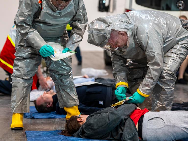 Sichtung von Patienten vor der Dekontamination von Verletzten Personen nach einem angenommen Unfall mit Gefahrstoffen, Patient ist intubiert und wird von Hand beatmet.