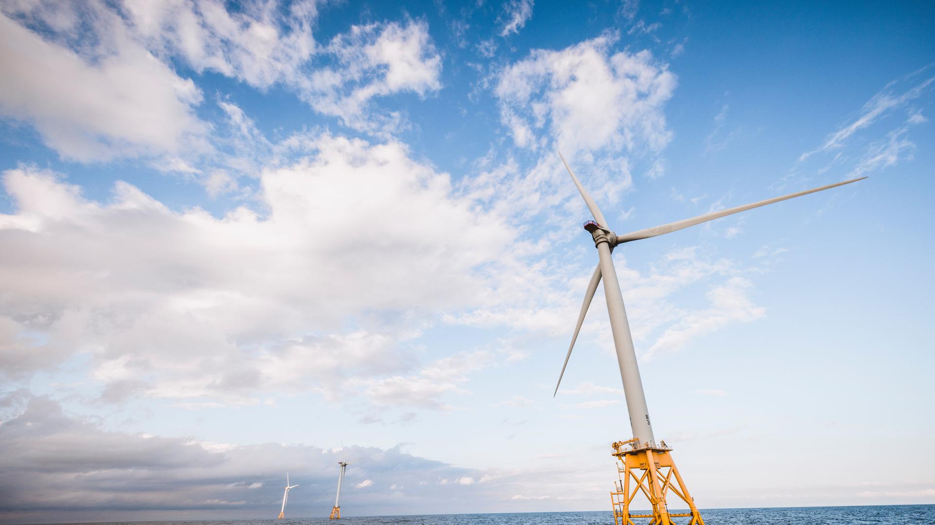 Eine Offshore-Windkraftanlage im US-Bundesstaat Rhode Island steht auf gelben Pfeilern schräg im Meer. Eine Offshore-Windkraftanlage im US-Bundesstaat Rhode Island steht auf gelben Pfeilern schräg im Meer.