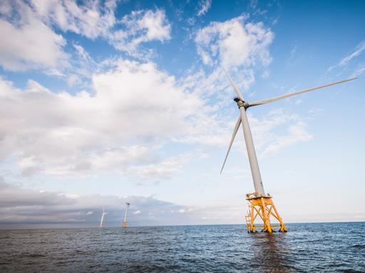 Eine Offshore-Windkraftanlage im US-Bundesstaat Rhode Island steht auf gelben Pfeilern schräg im Meer.