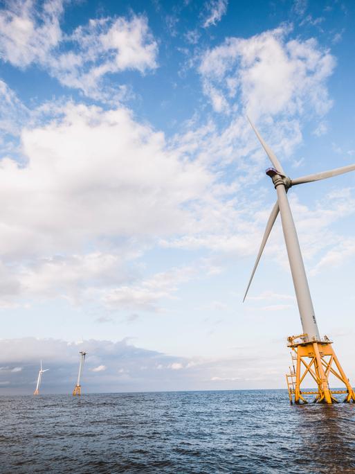Eine Offshore-Windkraftanlage im US-Bundesstaat Rhode Island steht auf gelben Pfeilern schräg im Meer.