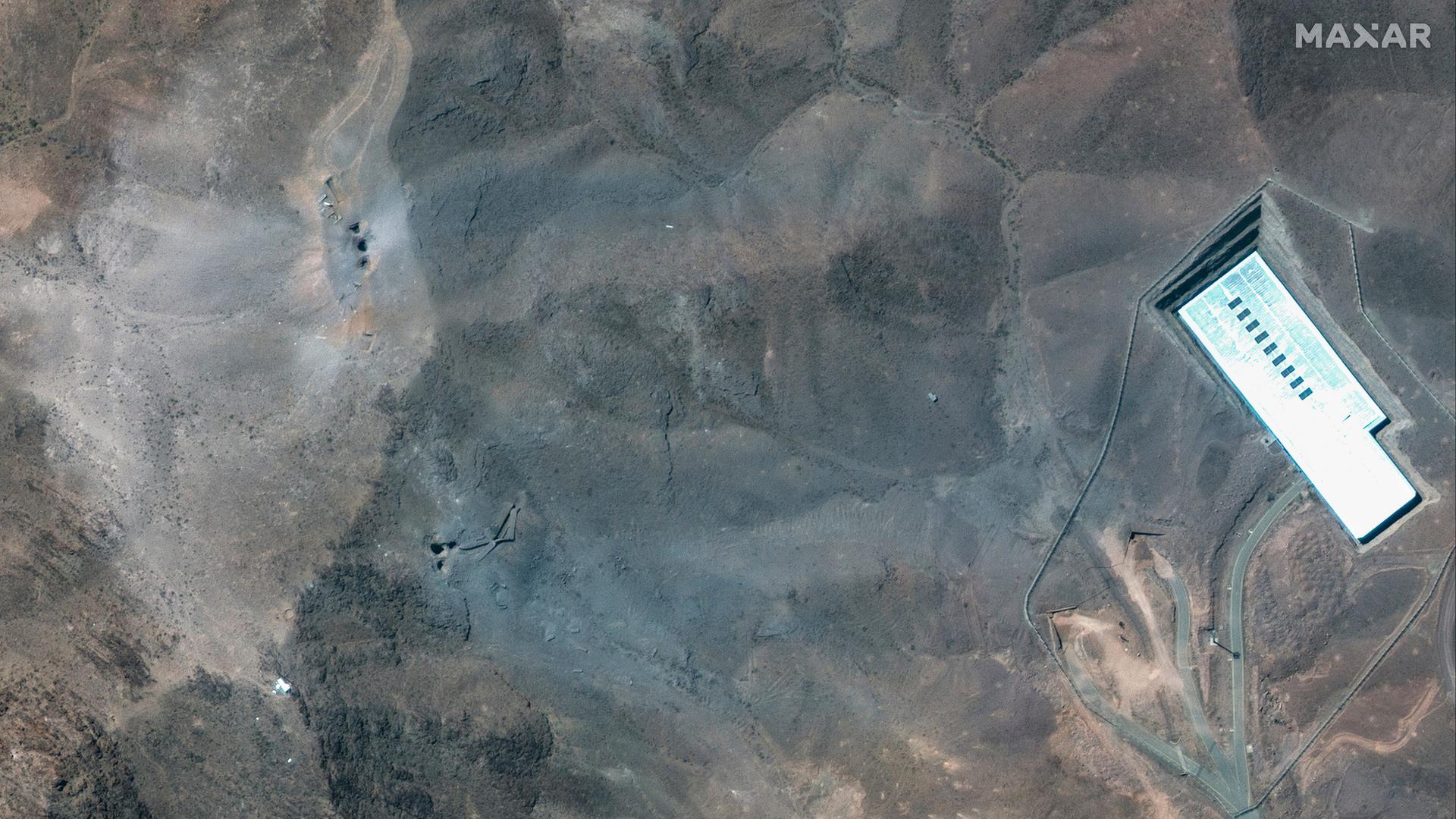 Dieses Satellitenbild von Maxar Technologies zeigt eine Nahaufnahme von Kratern und Asche auf einem Bergrücken. Dieses Satellitenbild von Maxar Technologies zeigt eine Nahaufnahme von Kratern und Asche auf einem Bergrücken.